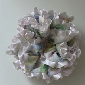 Close-up of floral scrunchie with purple patterns and white silk ruffled edges