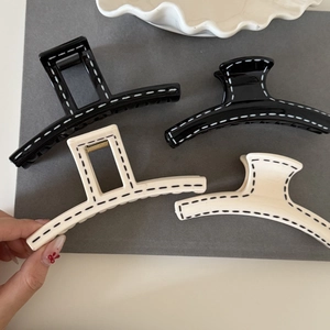 Minimalist black and white hair claws set with hand-painted stitching pattern