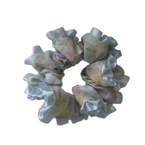Floral print scrunchie with pastel petals and light blue ruffled satin edge trim