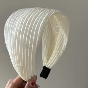 Detail showing the pleated white chiffon texture and black fabric ends of the headband
