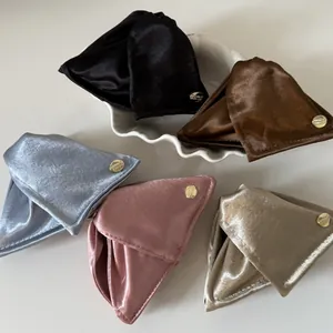 Detailed macro view of elegant satin shell hair claws in five soft colors with gold logos