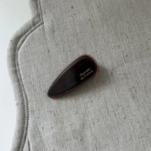 Detailed view of water-drop acetate hair clip in dark tortoiseshell with France logo