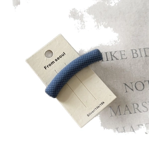 British style blue plaid fabric hair clip displayed on a minimalist beige card holder
