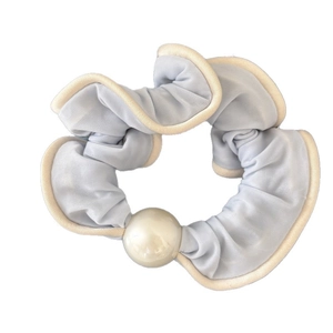 Lichtblauwe scrunchie met beige rand en een grote witte parel op glanzende satijnen stof
