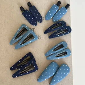 Vue détaillée de barrettes en denim bleu à pois de formes géométriques sur lin