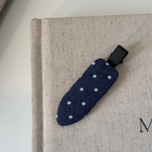 Barrette à cheveux à pois bleus sur couverture de livre en lin, accessoire élégant et chic
