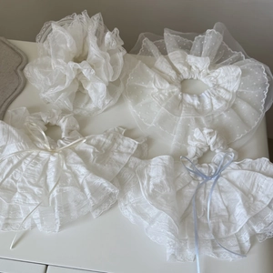 Dettaglio di quattro elastici per capelli in pizzo bianco con fiocchi eleganti e tulle