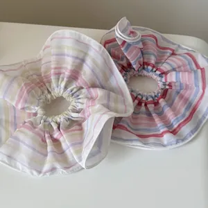 Close-up of rainbow striped fabric scrunchies showing fine texture and pleated edges