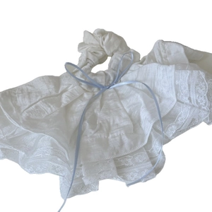 Elegante elastico in pizzo bianco con volant e un piccolo fiocco blu delicato