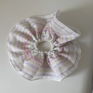 Rainbow striped fabric scrunchie with pastel pink and blue patterns on white background