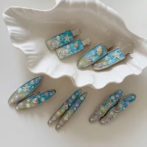 Set di fermagli per capelli blu a tema oceano con stelle marine e perle su vassoio