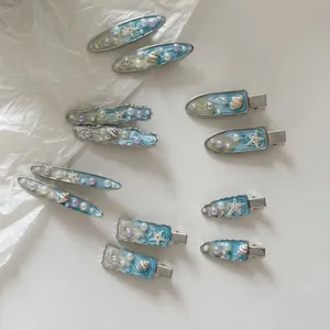 Set di fermagli marini con stelle marine e conchiglie in finitura blu sfumato