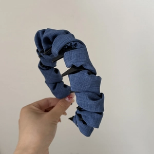 Detailed view of dark blue denim pleated headband with non-slip shark teeth design