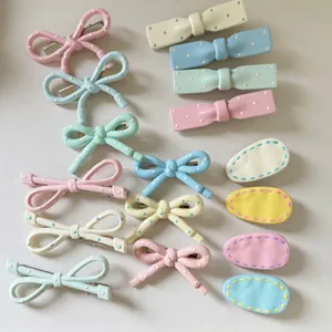Sweet macaron-colored hair clip set with cream bow and drop shapes on a leather background