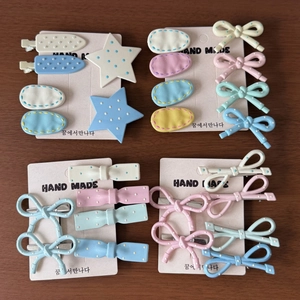 Detailed close-up of handmade cream-colored macaron hair clips set on paper cards