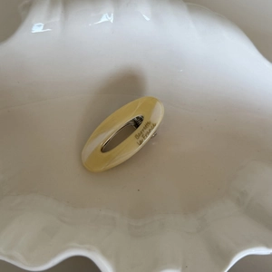 Detail of oval acetate hair clip with cream marble texture in white shell tray
