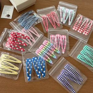 Detailed set of cute colorful plaid and polka dot metal BB hair clips in packaging
