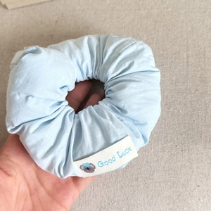 Light blue puff fabric scrunchie with cute koala tag and Good Luck text detail