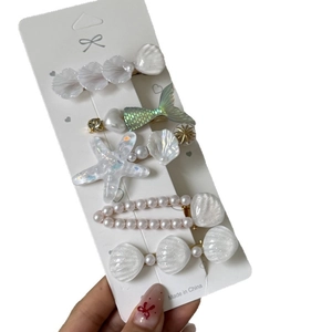 Lot de 5 barrettes sirène avec perles et coquillages sur support blanc de présentation