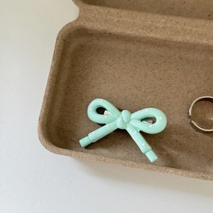 Detail of mint green hair clip with pink polka dots and silver metal duckbill base