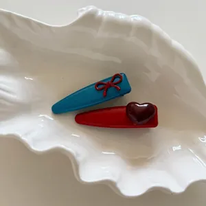 Set di fermagli per capelli con fiocchi blu e rossi su vassoio a forma di conchiglia