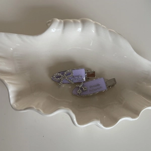 Grape purple hairpin set with rhinestone bow and cherry motifs on a shell tray