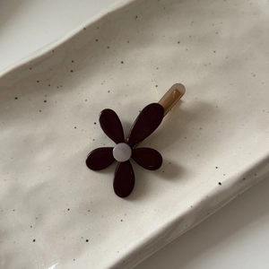 Fermaglio per capelli a fiore bordeaux con perla su un vassoio di ceramica