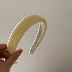 Detail of soft cream yellow patent leather headband with padded sponge for hair volume