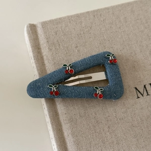Close-up of blue denim triangle hair clip with sparkling rhinestone cherry details