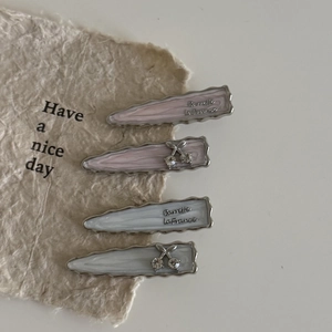 Close-up of marble pattern hair clips with cherry rhinestones on textured paper