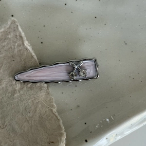 Detailed close-up of a lilac wavy hair clip with a silver cherry and rhinestones