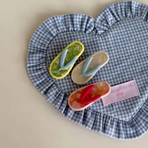 Three-piece flip-flop style acetate hair clips in green, beige and orange colors