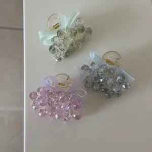 Three elegant crystal bead bow hair clips in light green, grey blue, and purple tones