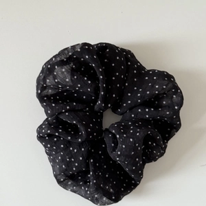 Classic black and white polka dot satin scrunchie for elegant low ponytail hairstyles