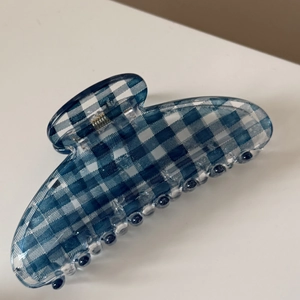 Detail of blue and white gingham pattern hair claw clip with a glossy finish