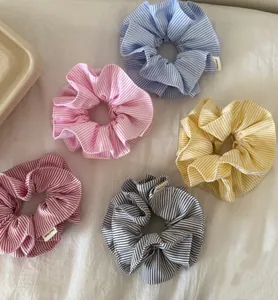 Detailed set of five colorful striped scrunchies with handmade labels on white fabric