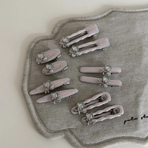 Macro view of ten lavender marble resin hair clips with silver starfish and heart charms