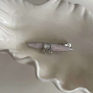 Pink starfish rhinestone hair clip with heart and shell elements on shell tray