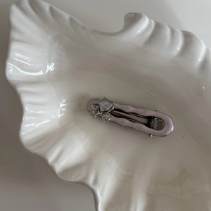 Pink starfish and heart rhinestone hair clip on a white ceramic shell tray for women