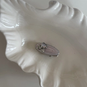 Detailed close-up of pink starfish hair clip with rhinestone and seashell elements