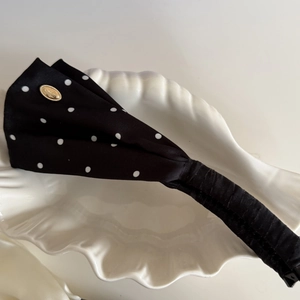 French vintage black satin polka dot hair clip on a white shell decorative tray