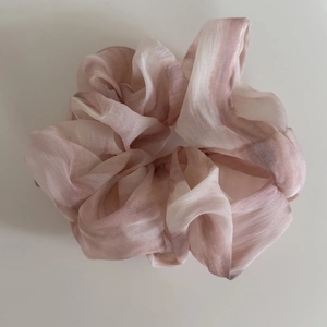 Detailansicht eines großen Haargummis mit rosa-weißem Marmor-Tie-Dye-Muster