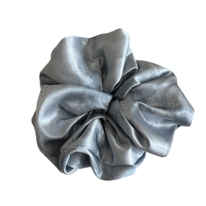 Eleganter sternenblauer Satin-Scrunchie mit sanftem Glanz und Falten auf weißem Hintergrund