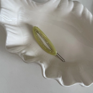 Gros plan sur la barrette ovale en strass avec gravure Creation France sur le clip