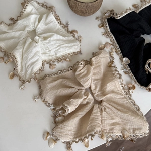 Detail of seashell and starfish charms on cotton linen hair scrunchies in three colors