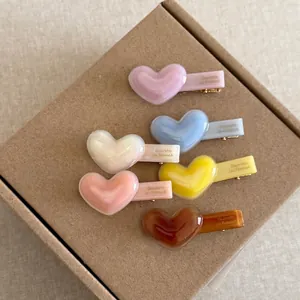 Set of 6 minimalist heart-shaped acetate hair clips in pastel colors with gold metal grip