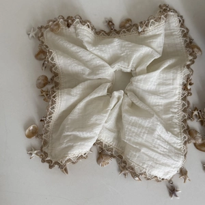 Detail of linen scrunchie with crochet lace edge and starfish seashell charms