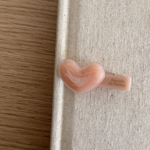 Pink marble heart-shaped acetate barrette hair clip with gold-stamped lettering logo