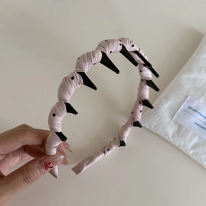 Close-up of pink polka dot headband showing non-slip teeth and woven fabric detail