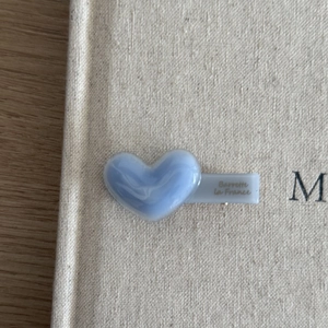 Detail shot of heart-shaped blue marble acetate hair clip with golden Barrette La France text